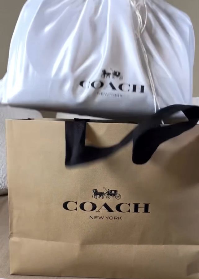 White Coach bag in its dust bag and Coach shopping bag